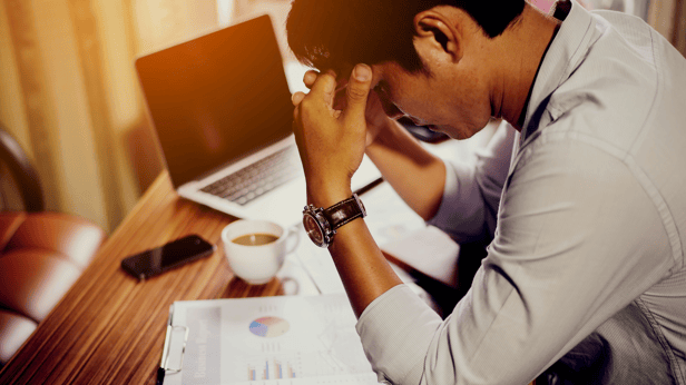 man leaning over desk, burnt out