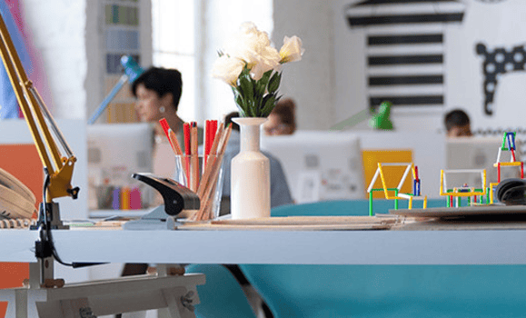 White flowers on a desk in an office.