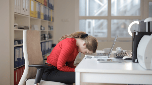 Woman with her head on her desk