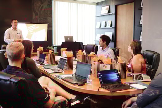 Employees sitting around a table with gift bags in front of them